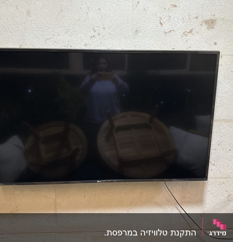 טלוויזיה תלויה על קיר עם כבל חשמל